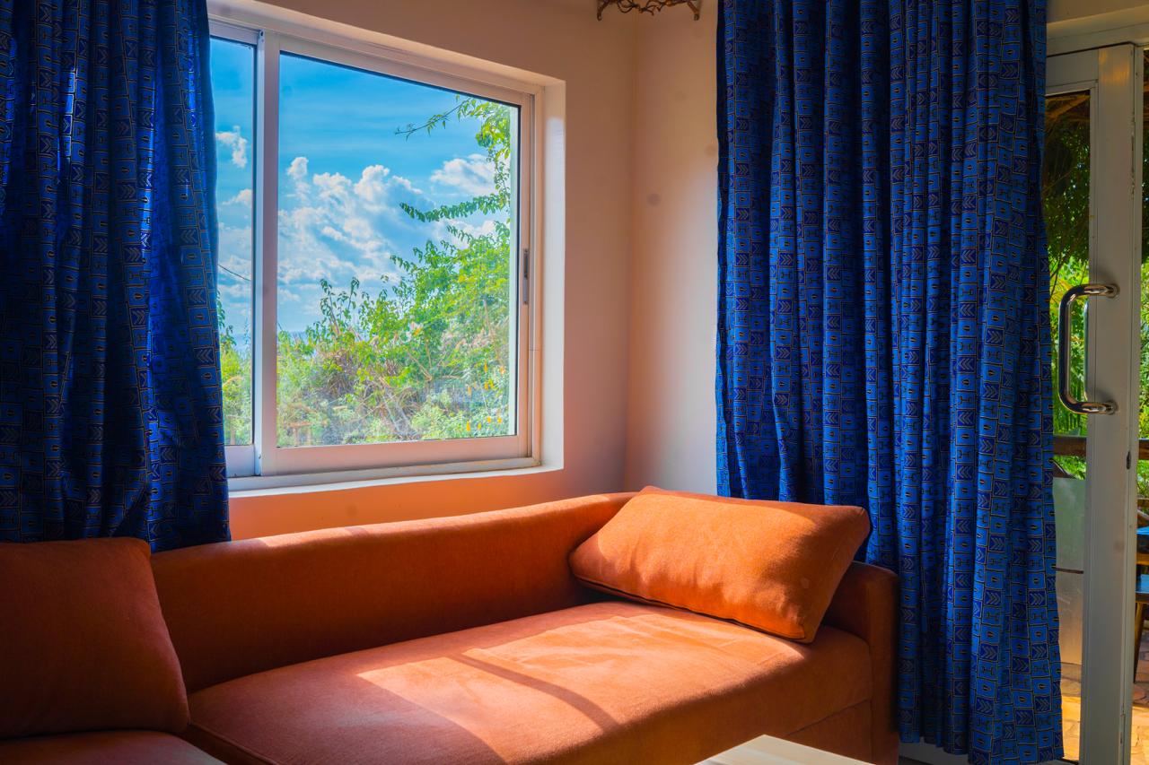 Sunlit living room with orange sofa and garden view