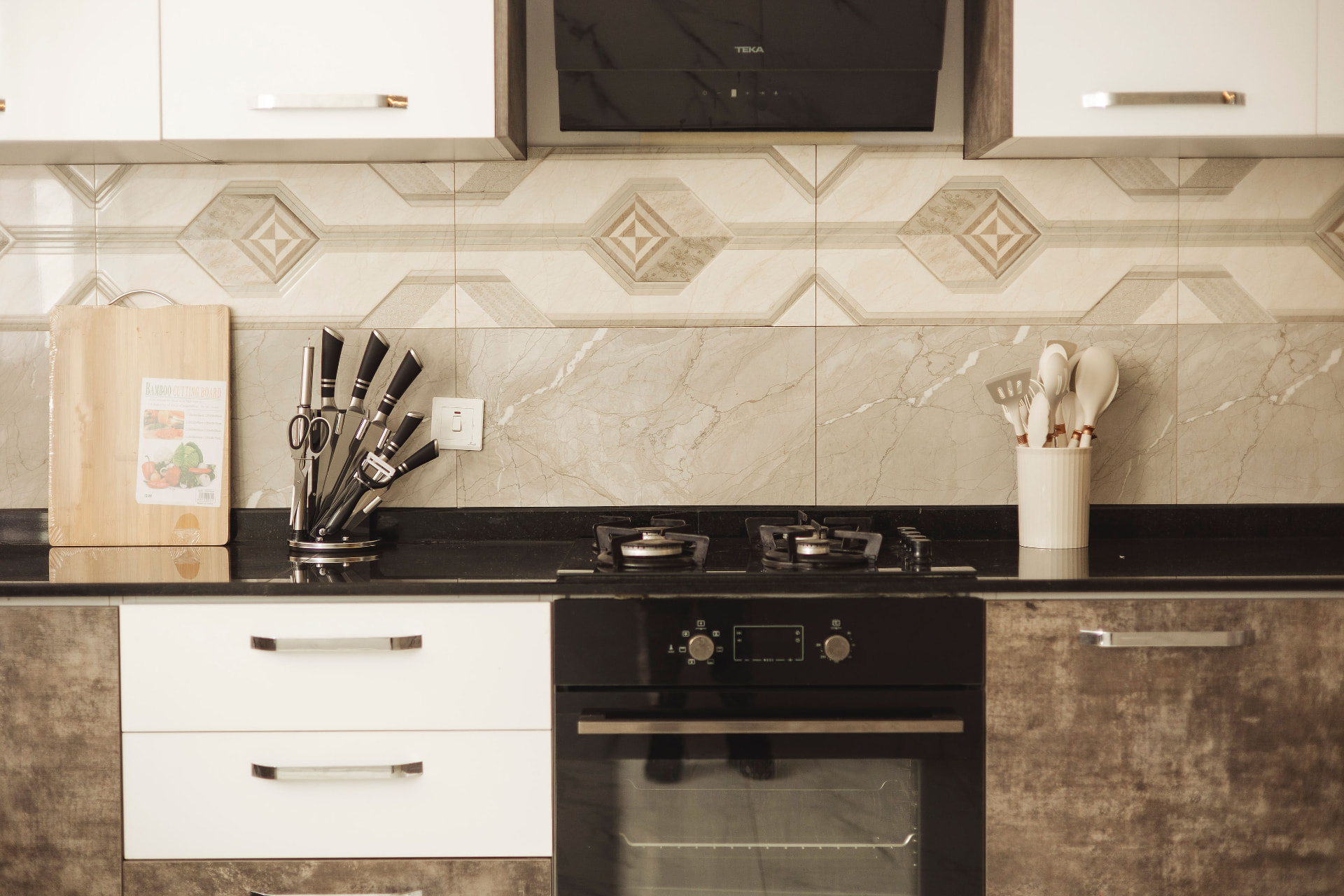 Fitted kitchen with gas hob, oven and marble backsplash