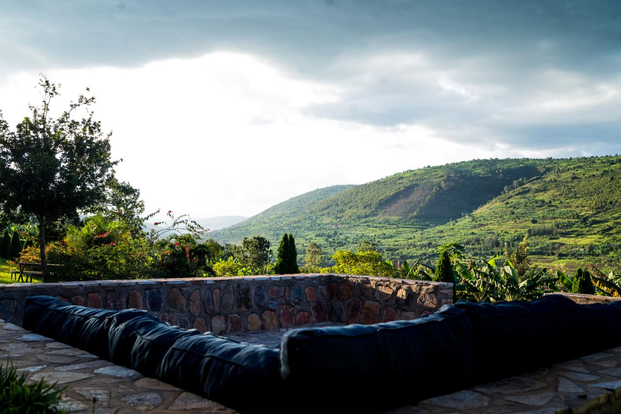 Stone-walled patio lounge overlooking green hills at Lalaha Cottage