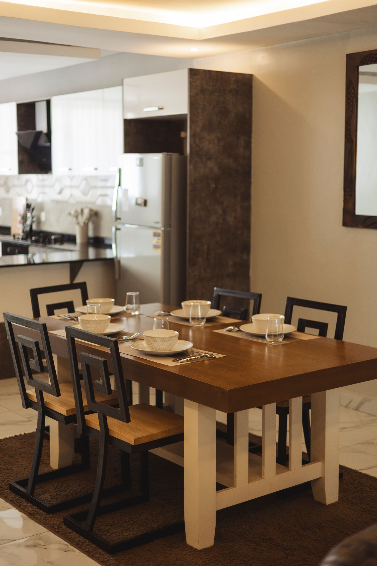 Dining table set for six beside the open kitchen