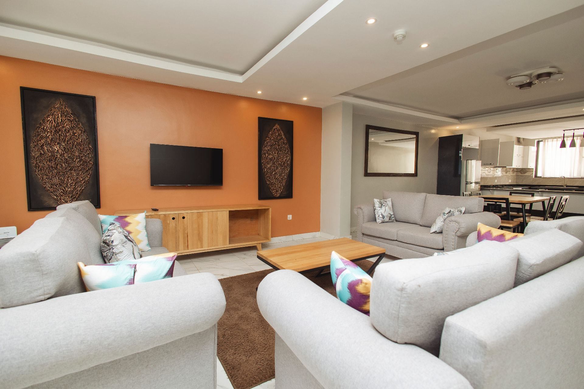 Open-plan lounge with accent wall and dining area beyond